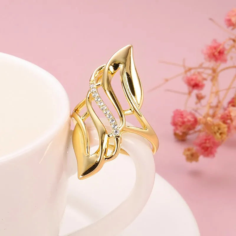 Women's exaggerated curve fashion ring in Q611 gold colour, made from copper with sparkling zircon stone accents.