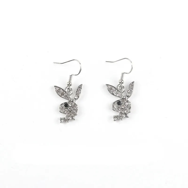 Close-up of a pair of small silver rabbit stud earrings with a sparkling rhinestone set in the centre on a white background.