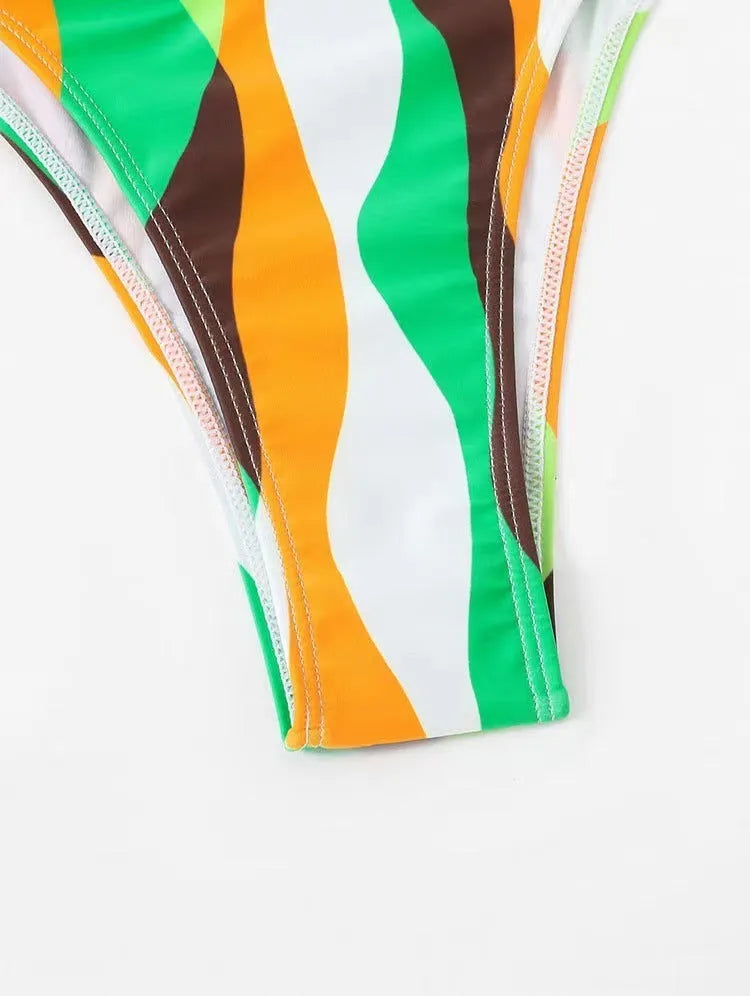 Yellow green printed women's bikini set with top, briefs, and matching beach skirt laid flat.
