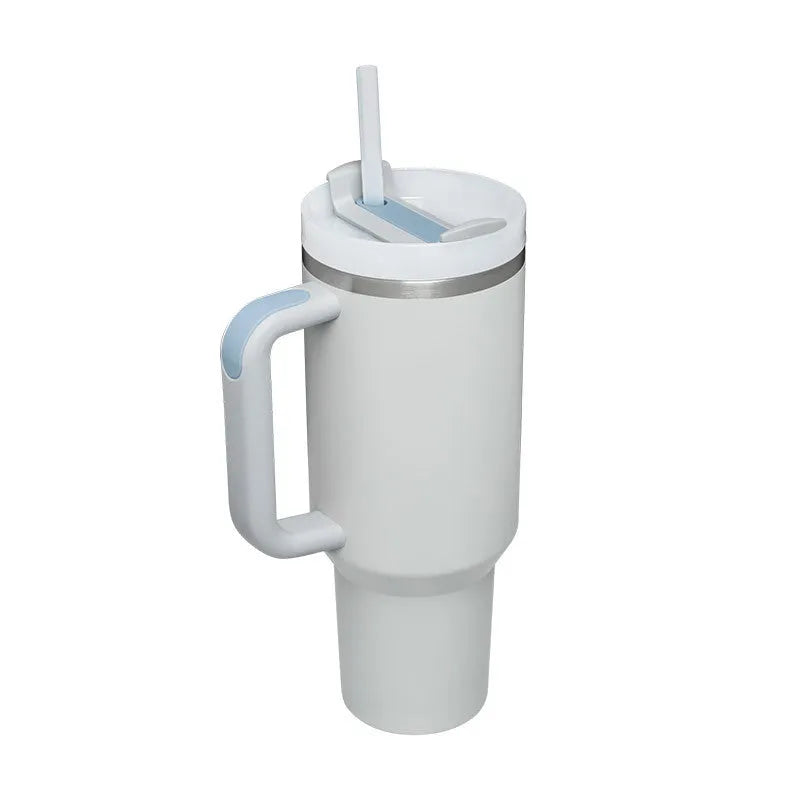 40 oz stainless steel insulated tumbler with a black handle, straw, and grey lid on a wooden table
