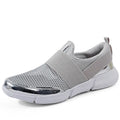 Blue low-top women's sneakers with mesh fabric and a lightweight sole on a hard floor
