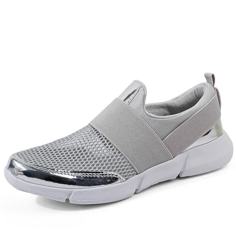 Low-cut blue women's casual sneakers with a breathable mesh design on a hard floor