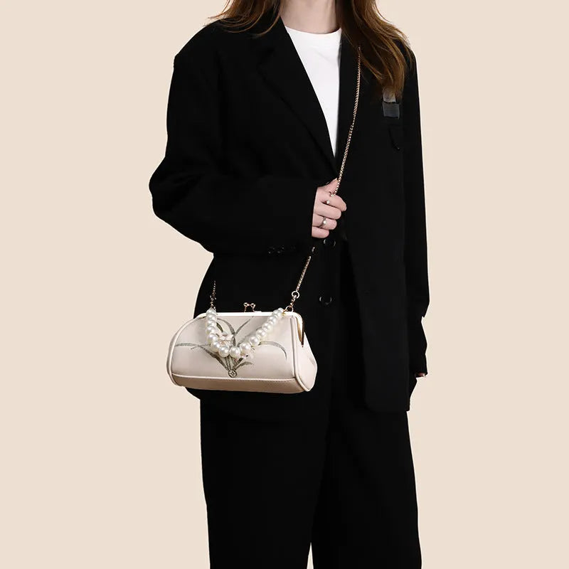 Beige shell-shaped women's shoulder bag with embroidery detail on soft PU leather.
