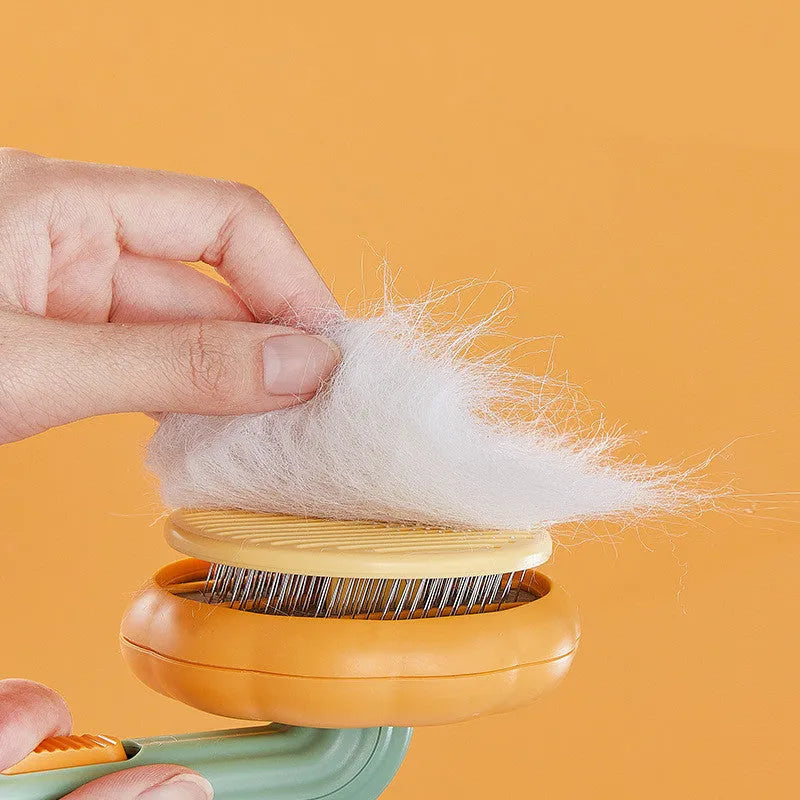 Pumpkin-coloured hand-held pet brush with curved stainless steel teeth for grooming cats and dogs