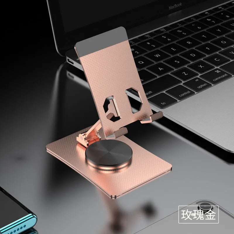 Aluminium alloy rotating mobile phone bracket in silver on a desk, showing three-axis joint and metal texture finish