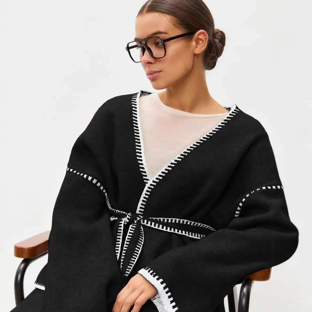 Loose fit lace-up knitted cardigan in black, shown as a mid-length sweater coat.