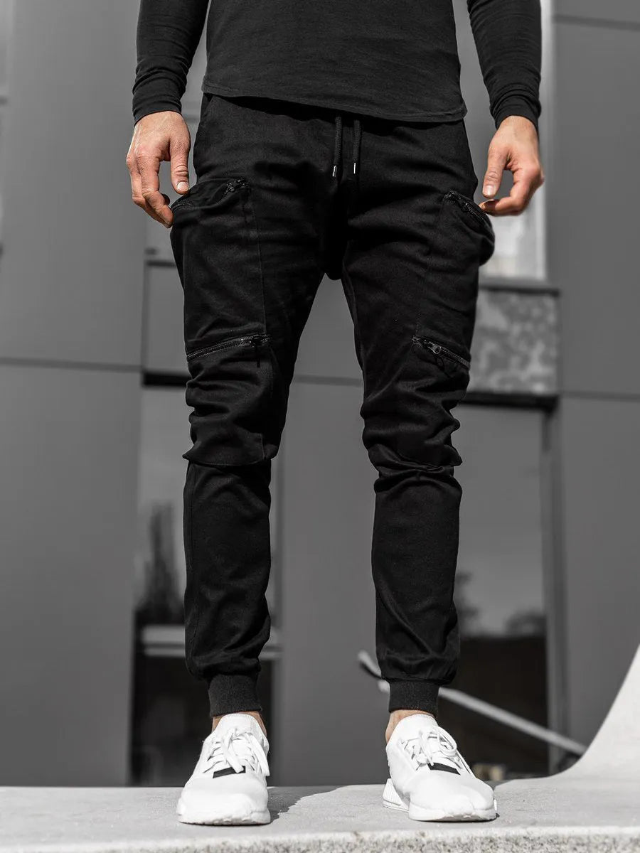 Men's tight fit multi-pocket cotton trousers in black, shown with multiple front pockets and tethered details on waistband.