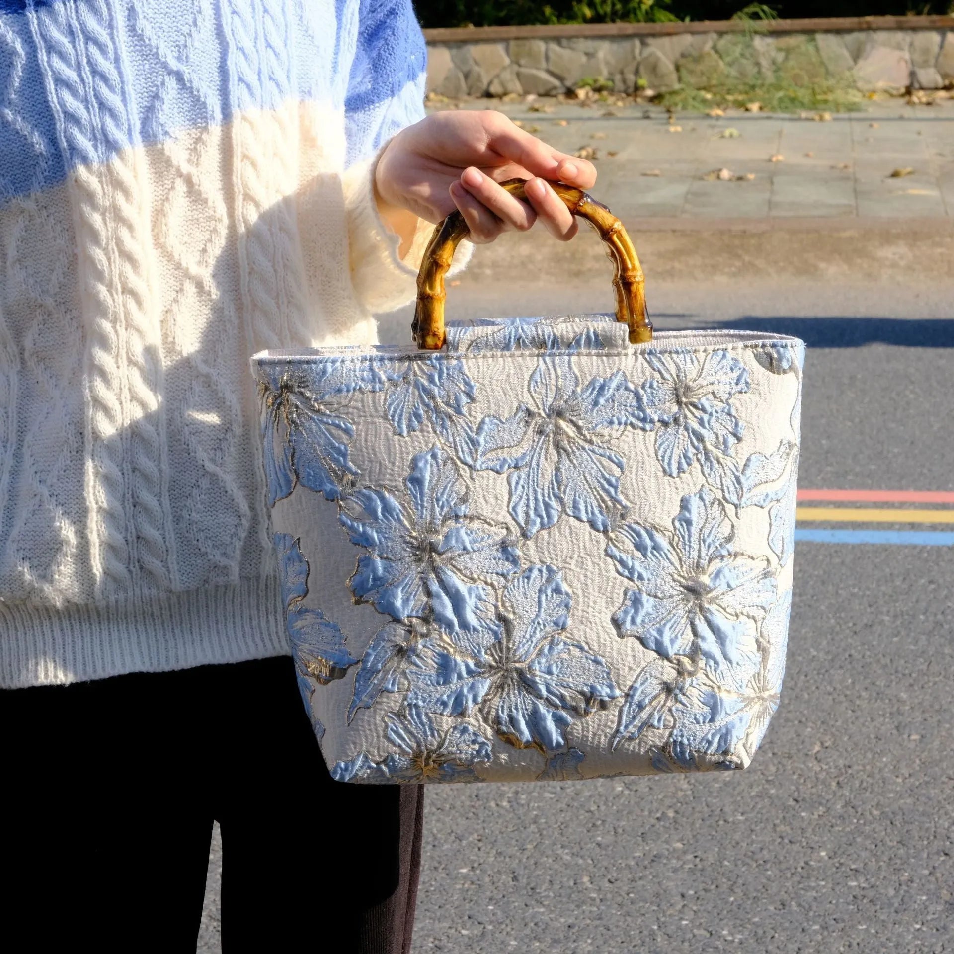 Light blue canvas shoulder bag with bronzing flower pattern, showing square shape and double shoulder straps