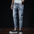 Light blue denim cropped jeans with ripped details on straight leg