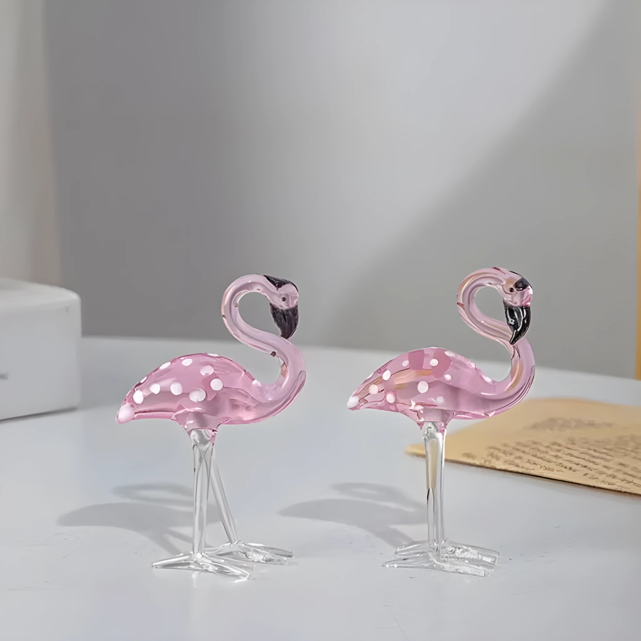 Pink flamingo crystal decorative ornament on a table in modern minimalist style.