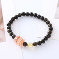 Handmade black obsidian and gold Pi Xiu charm bracelet with red flowers.