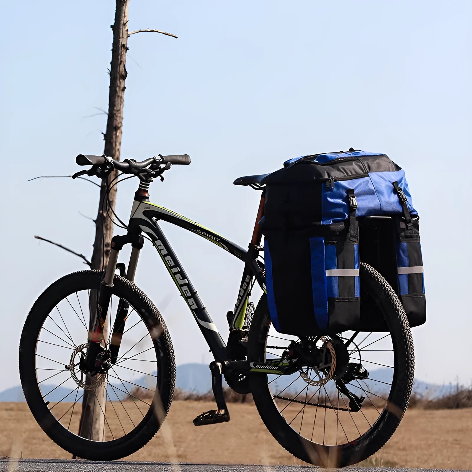 Green 70 litre bicycle rear storage frame bag mounted on a bike for touring.