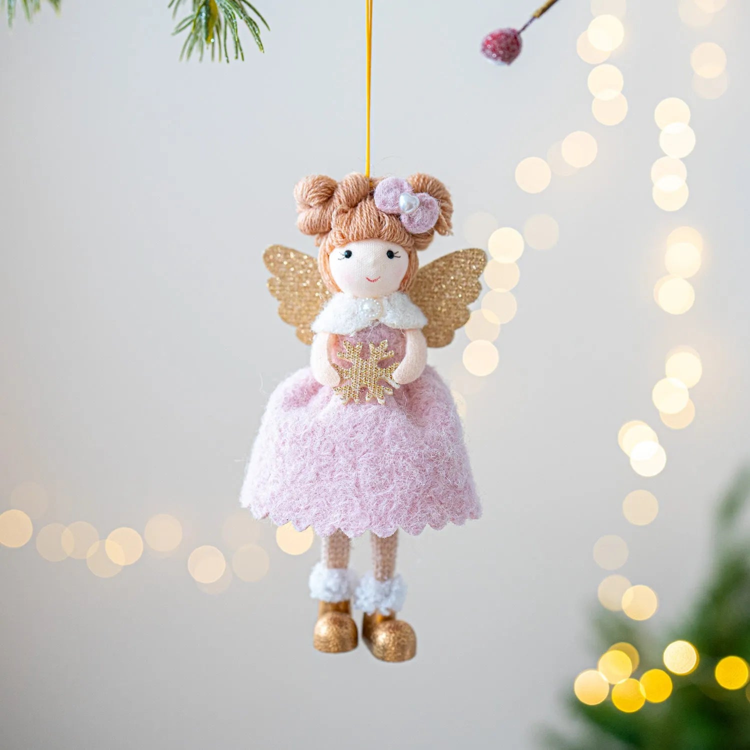 Pink and white cloth Christmas angel wings plush pendant decoration on a neutral background.