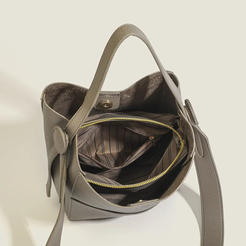 Bucket-style PU messenger bag with sewing line detail, available in black, brown, and elephant gray, on a plain background