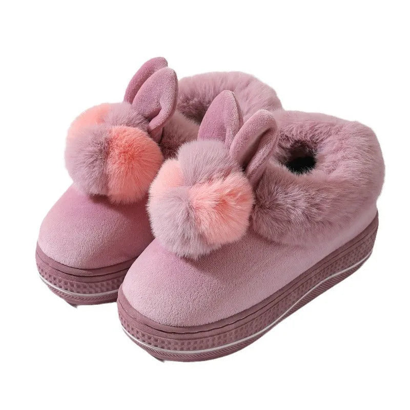 A pair of high-heel winter slippers with a plush fabric upper and a thick TPR sole.