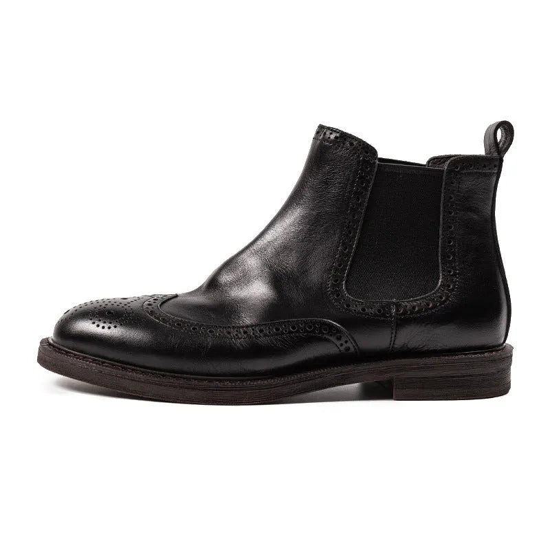 Men's black Chelsea boots with brogue carved genuine leather upper and rubber sole, side view