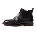 Men's black Chelsea boots with brogue carved genuine leather upper and rubber sole, side view