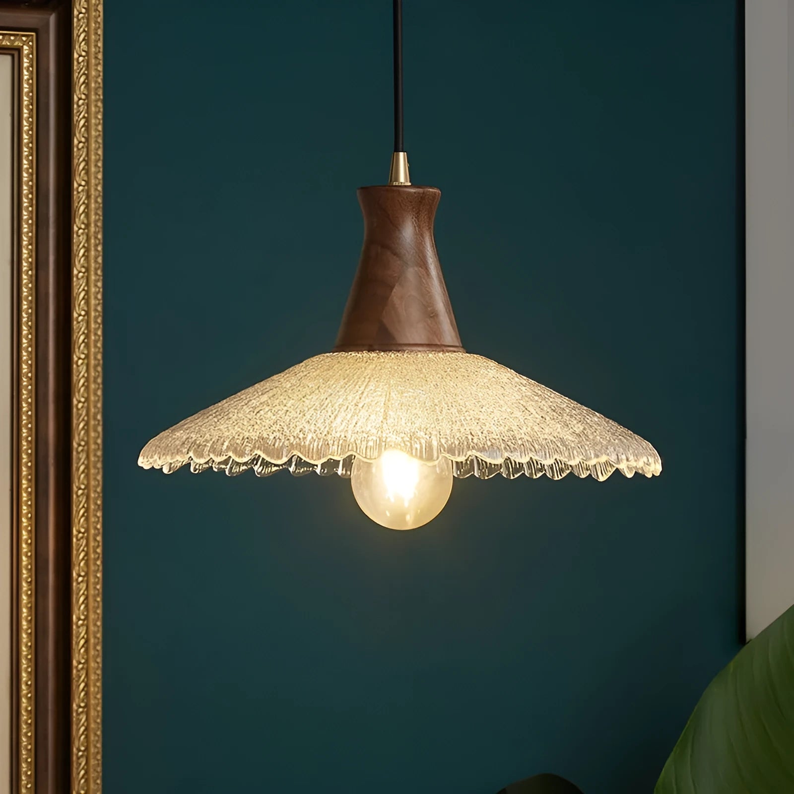 Retro chandelier with wooden body, brass metalwork, and a clear glass shade hanging from the ceiling.