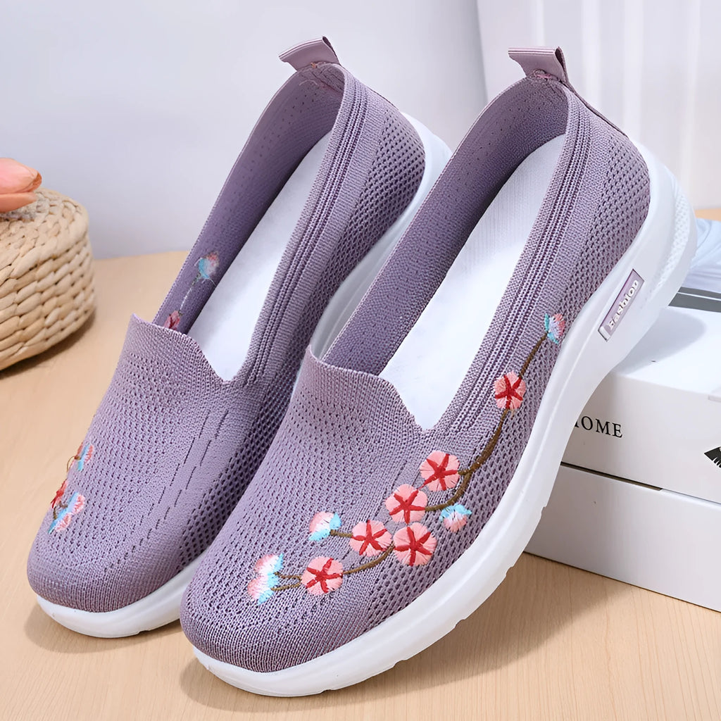 Women's black woven ballet pumps with floral embroidery and a flat anti-slip sole.