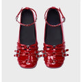 Black women's patent leather buckle pumps with a square toe and flat rubber sole.