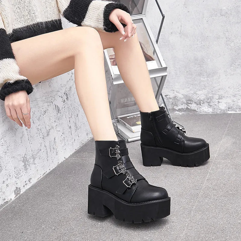 Black women's ankle boots with bat buckle, side zip, and thick heel.