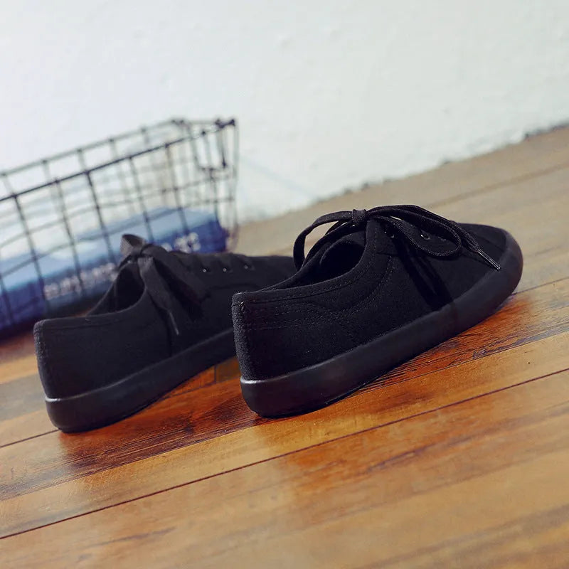 All black women's flat canvas lace-up shoes with a rubber sole