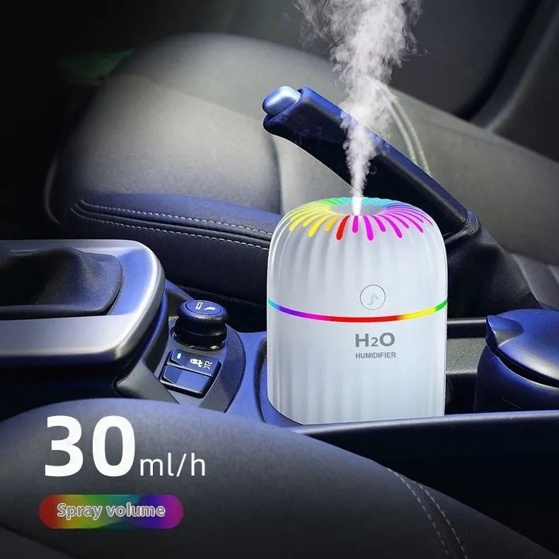 Small green animal-shaped USB humidifier and essential oil diffuser on a car dashboard.