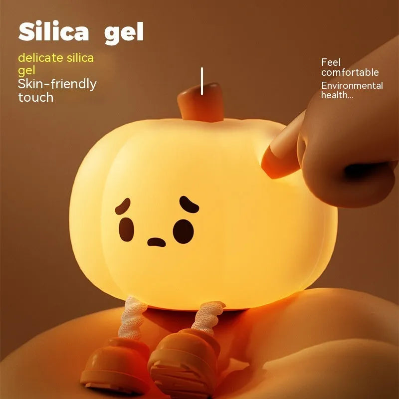 Orange silicone pumpkin night light with USB charging port and cotton accents, displayed as decorative lantern