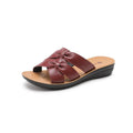 Women's beige cowhide slippers with a soft sole on a plain background.