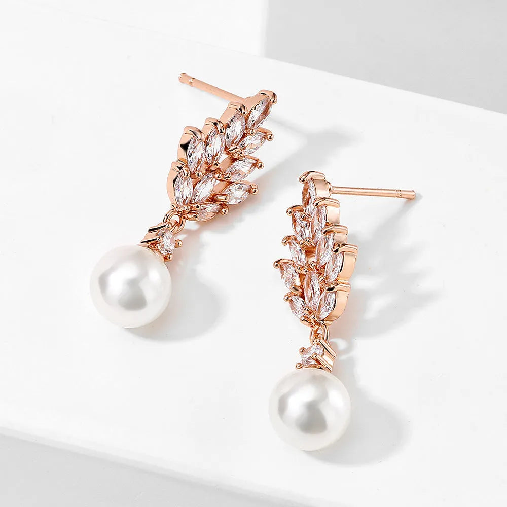 Geometric earrings with white floral micro inlay on a gold, rose gold, or platinum plated background.