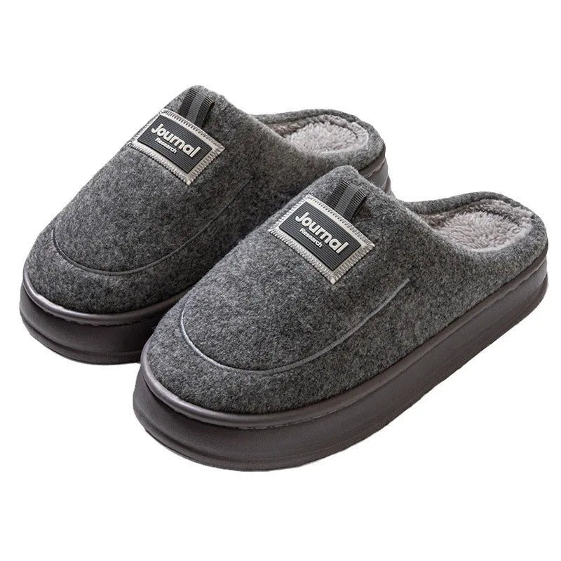 Men's grey suede slippers with a thickened sole shown on a wooden floor.