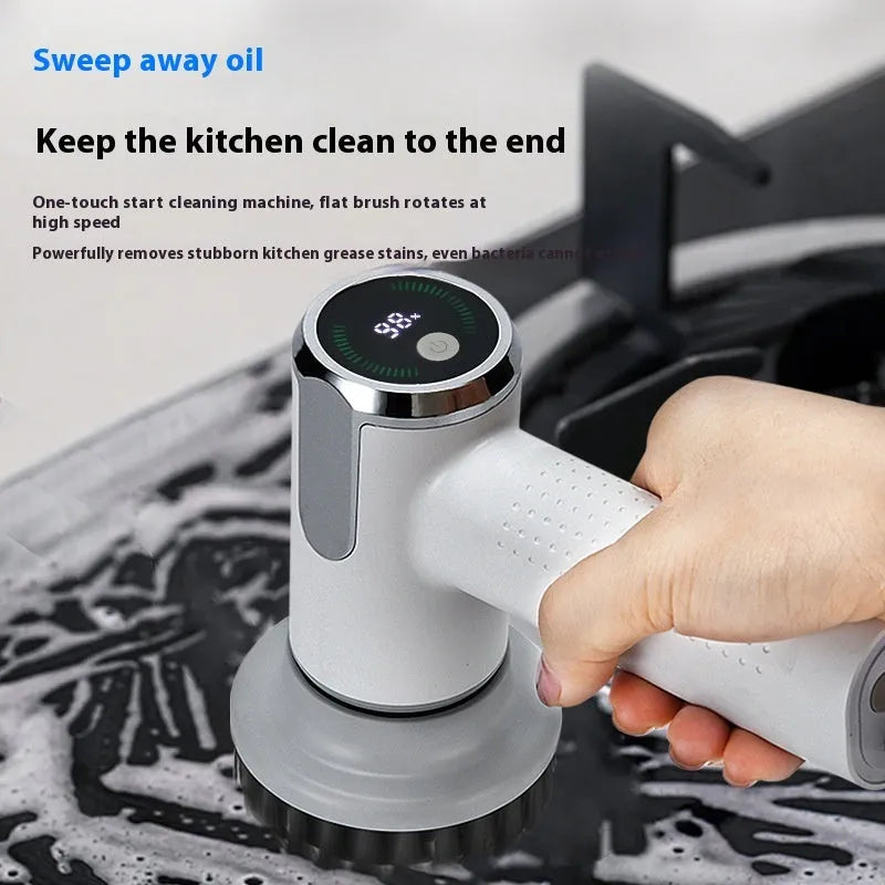 White cordless electric cleaning brush with interchangeable heads on a kitchen counter.