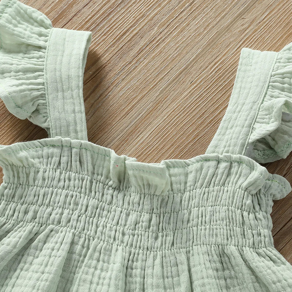 Green cotton girls' two-piece set with sleeveless sling top and matching short hot pants.