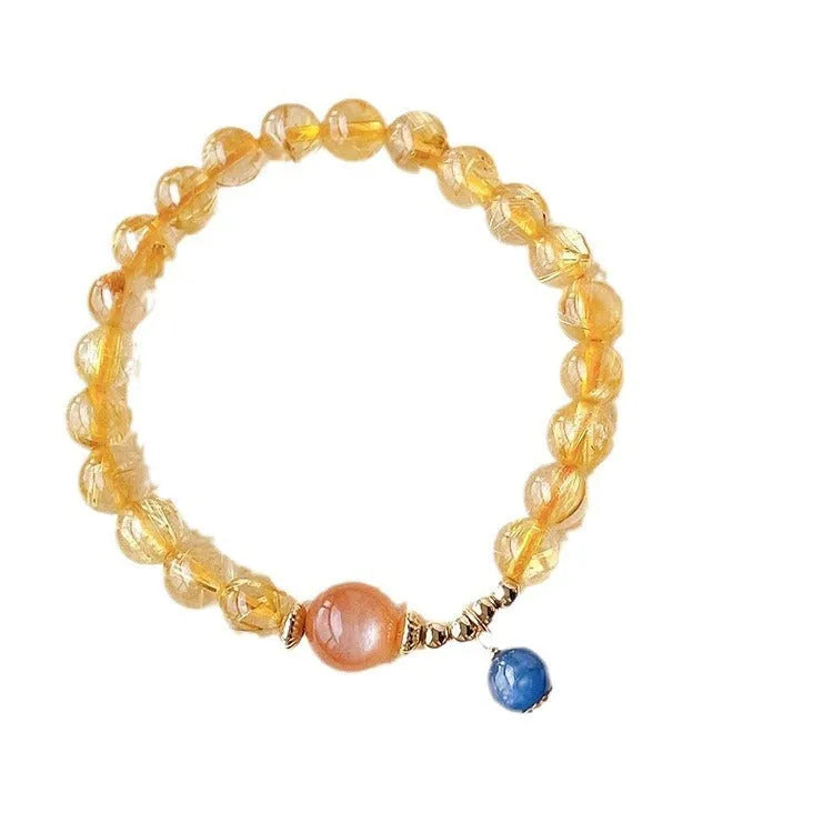 Gold rutilated quartz sunstone crystal bracelet with diamond-cut beads on wrist