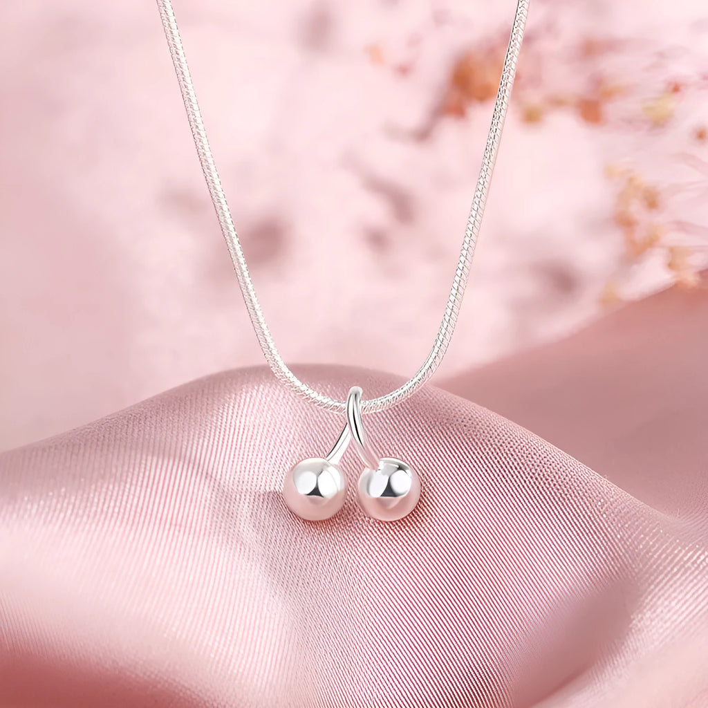 Silver cherry pendant necklace on an adjustable snake bone chain for women.