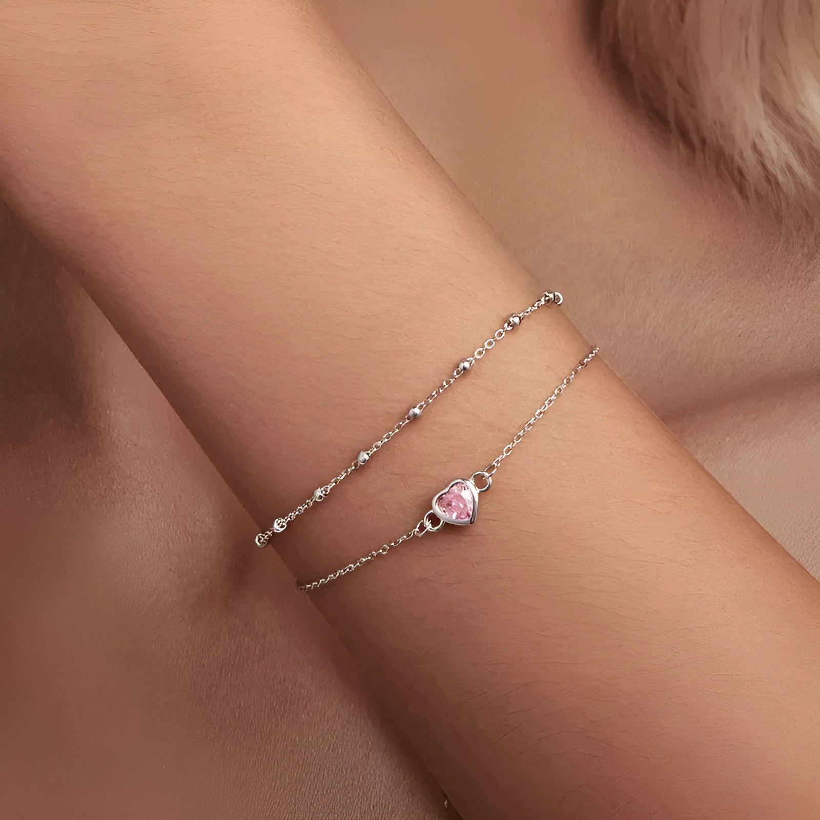 Silver heart-shaped charm bracelet for women on an adjustable chain.