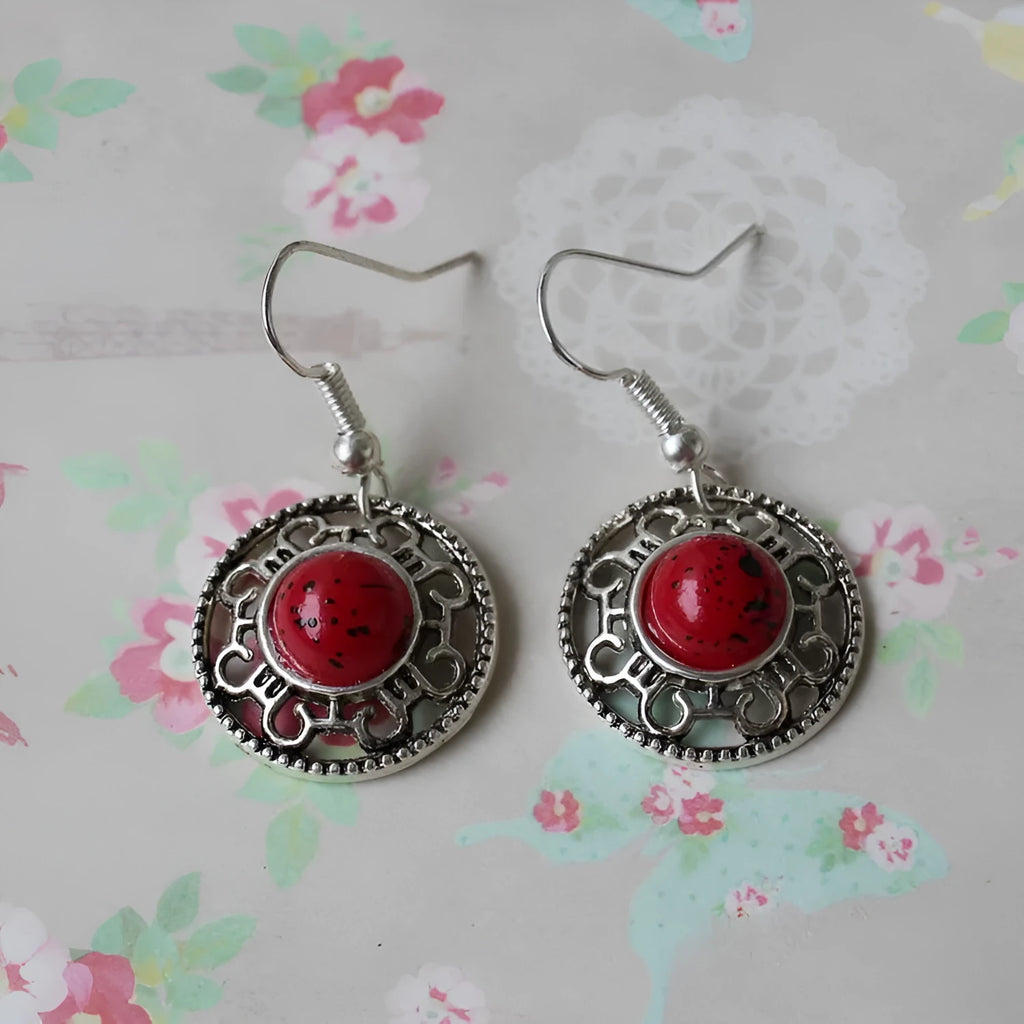 Handmade geometric silver earrings with turquoise flower disk and ethnic patterns in red, blue, or black.