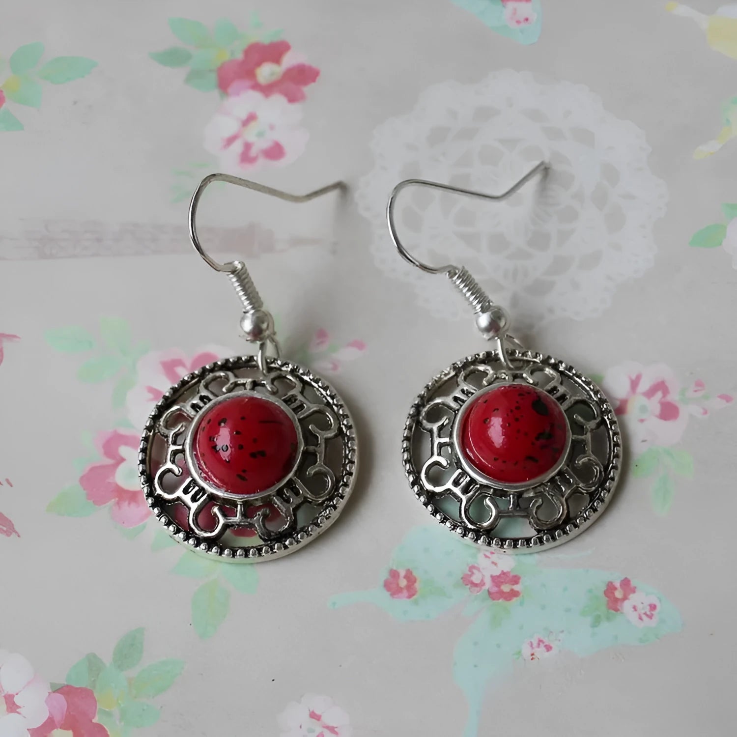 Handmade geometric silver earrings with turquoise flower disk and ethnic patterns in red, blue, or black.
