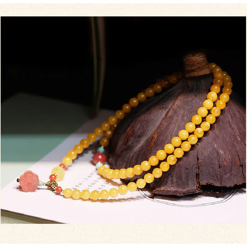 Yellow amber chicken grease beeswax bracelet with 5mm beads and Zodiac modelling on a wrist.