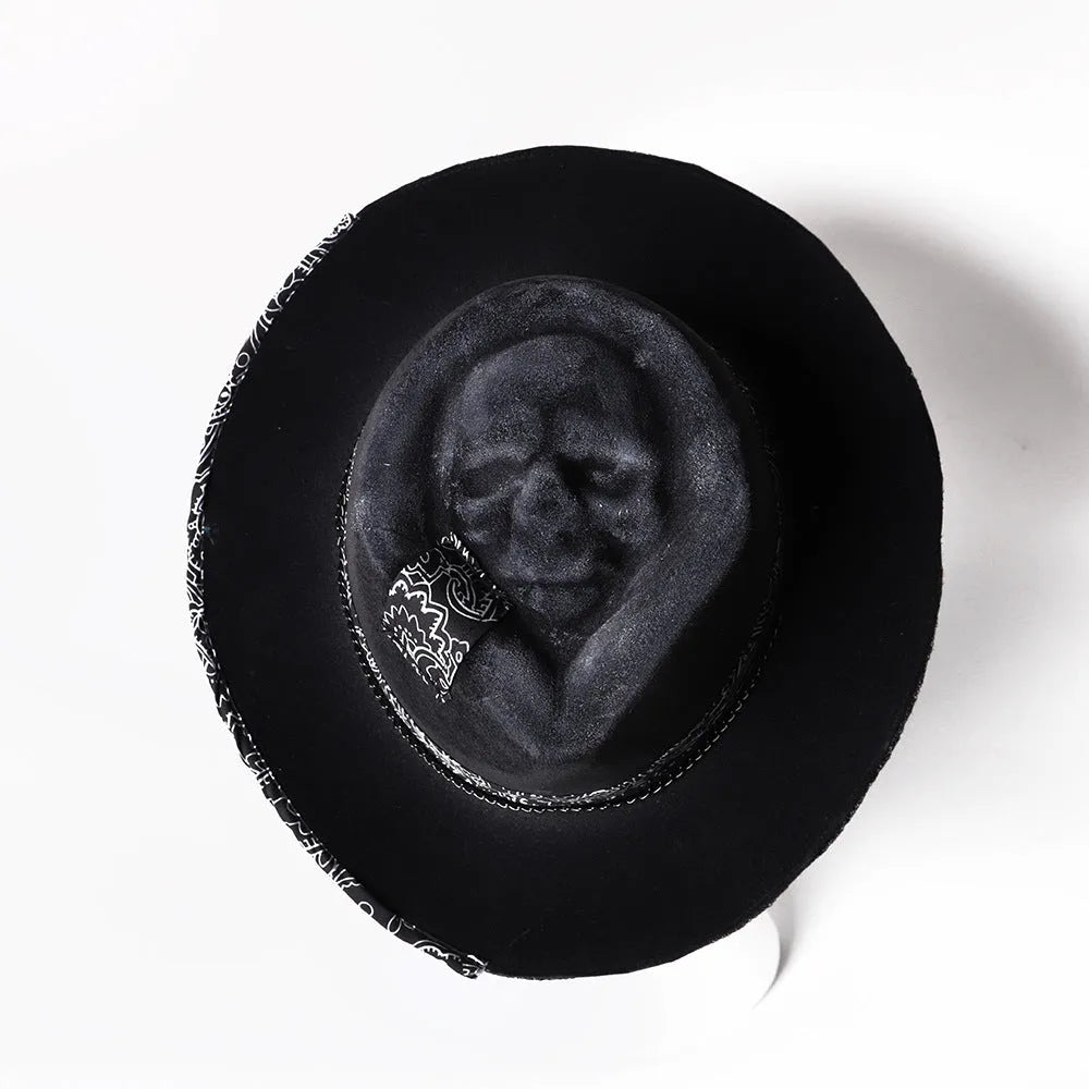 Handmade wool felt conical crown skull hat for Halloween costumes on a dark background.