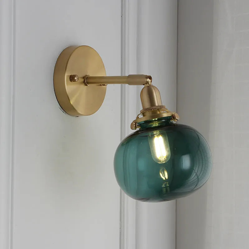 Hand-blown transparent water ripple glass wall lamp mounted on a beige wall, emitting a soft amber glow
