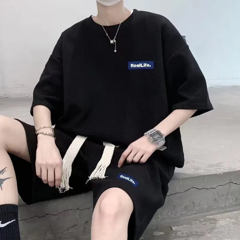 Men's waffle texture leisure set comprising a grey short-sleeve T-shirt and matching shorts on a hanger.