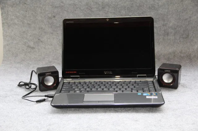 Small square black USB-powered 2.0 desktop computer speaker on a desk.