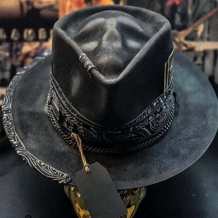 Handmade wool felt conical crown skull hat for Halloween costumes on a dark background.