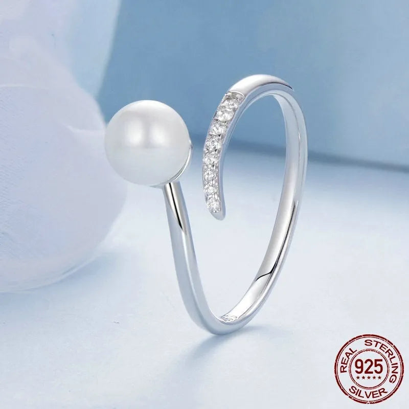 Adjustable open-loop sterling silver ring featuring a genuine shell pearl.