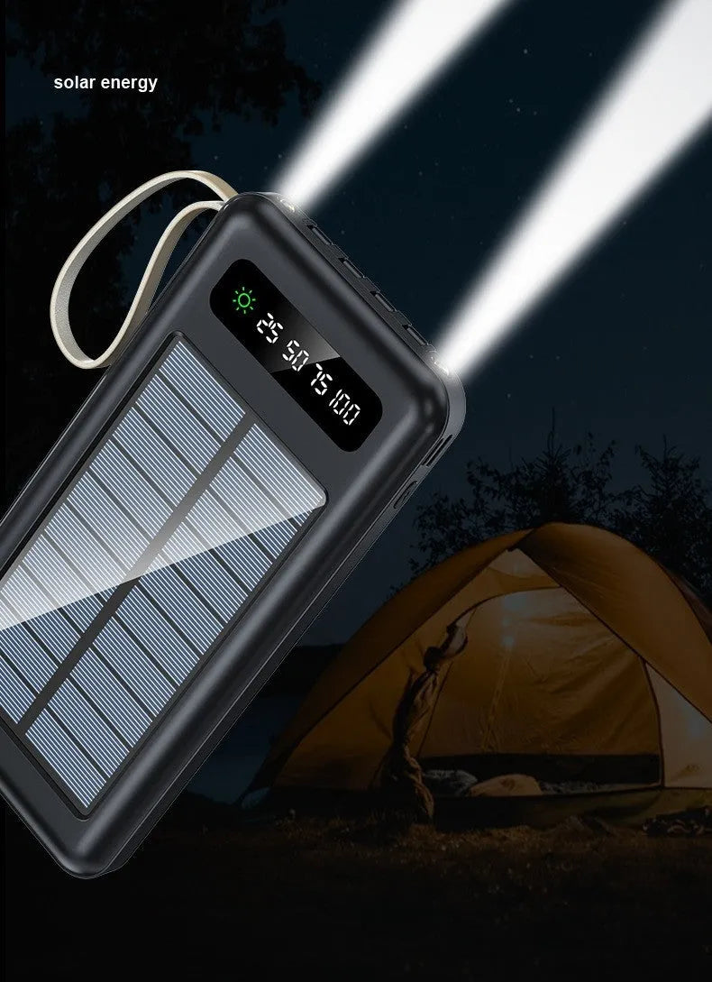 Black and white solar power bank showing size, solar panel, and USB ports for charging phones outdoors.
