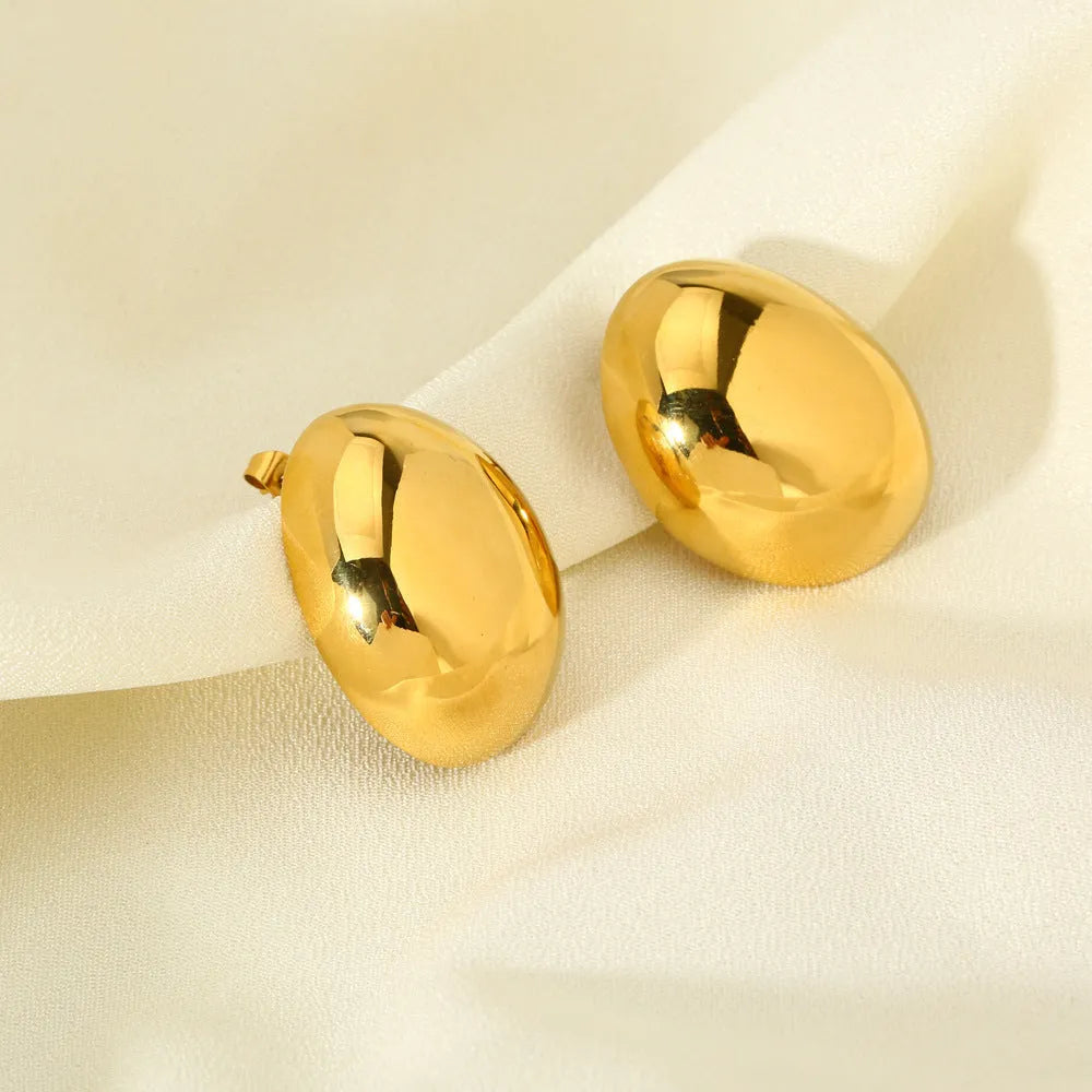 Geometric gold-coloured ear studs with glazed surface and line design details
