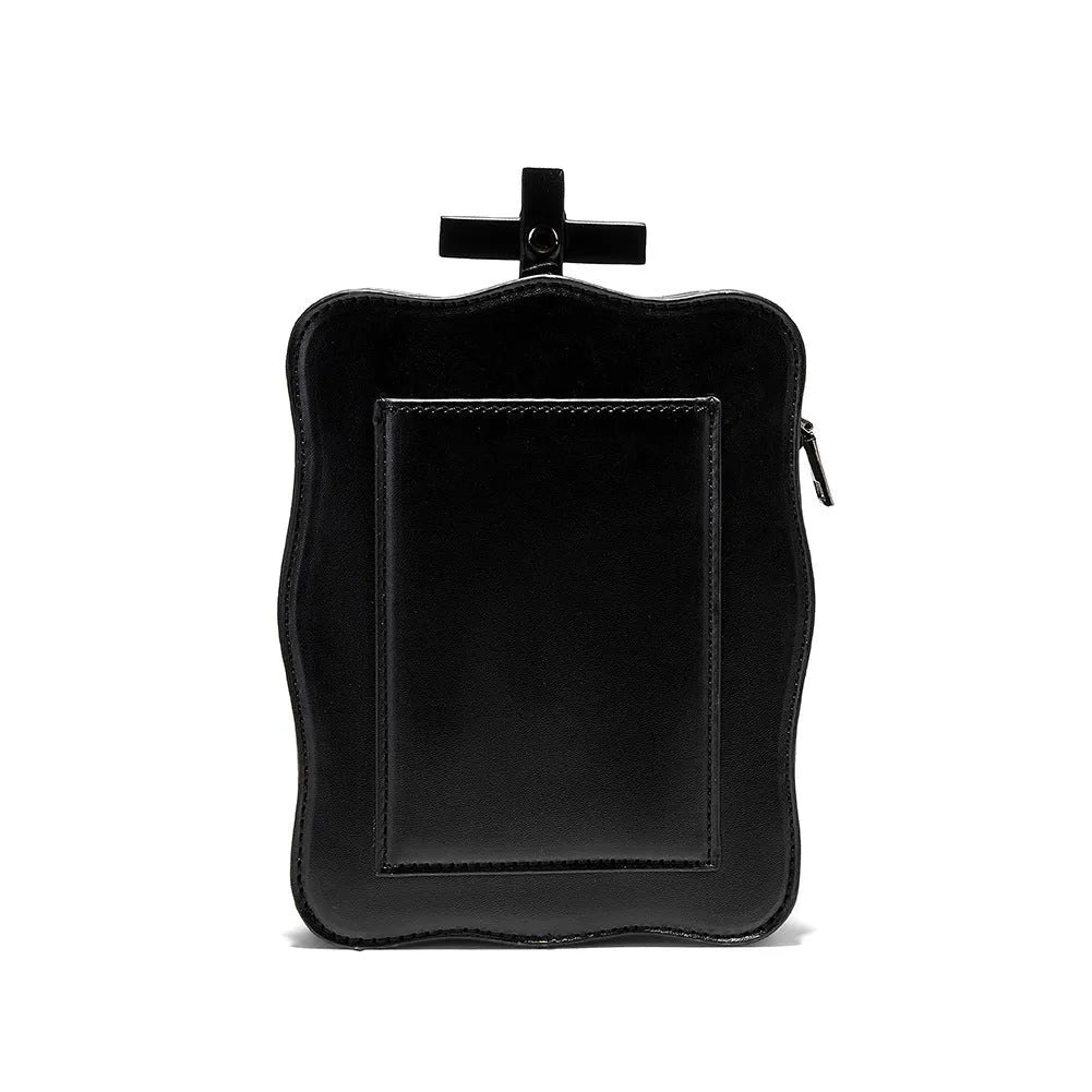 Black mini square crossbody bag with embossed skull design, metal rivets, chain strap, and top zipper.