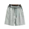 Man wearing loose-fit, light blue cotton shorts with distressed detailing and a straight-leg cut.