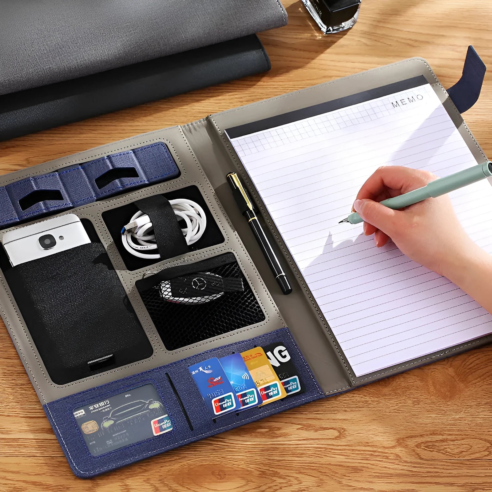 Black full-grain leather A4 document folder with 35mm thick sides, shown open with a notepad and pen.